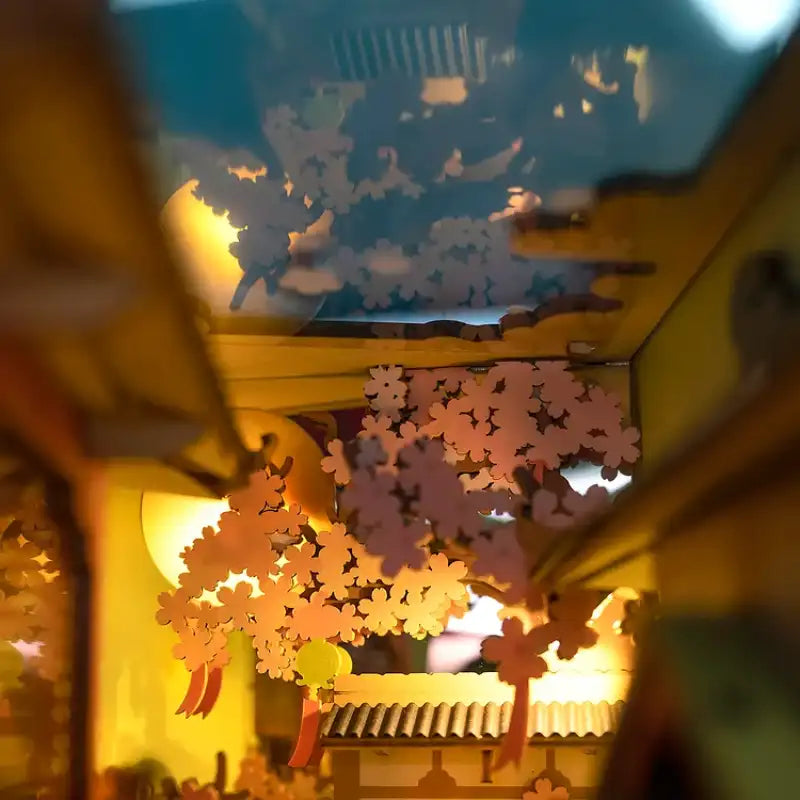 Złożony Book Nook Falling Sakura na półce z książkami