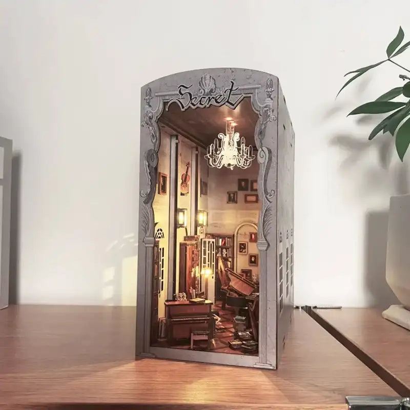 Złożony Book Nook Secret Piano Room z detalami instrumentów na półce z książkami